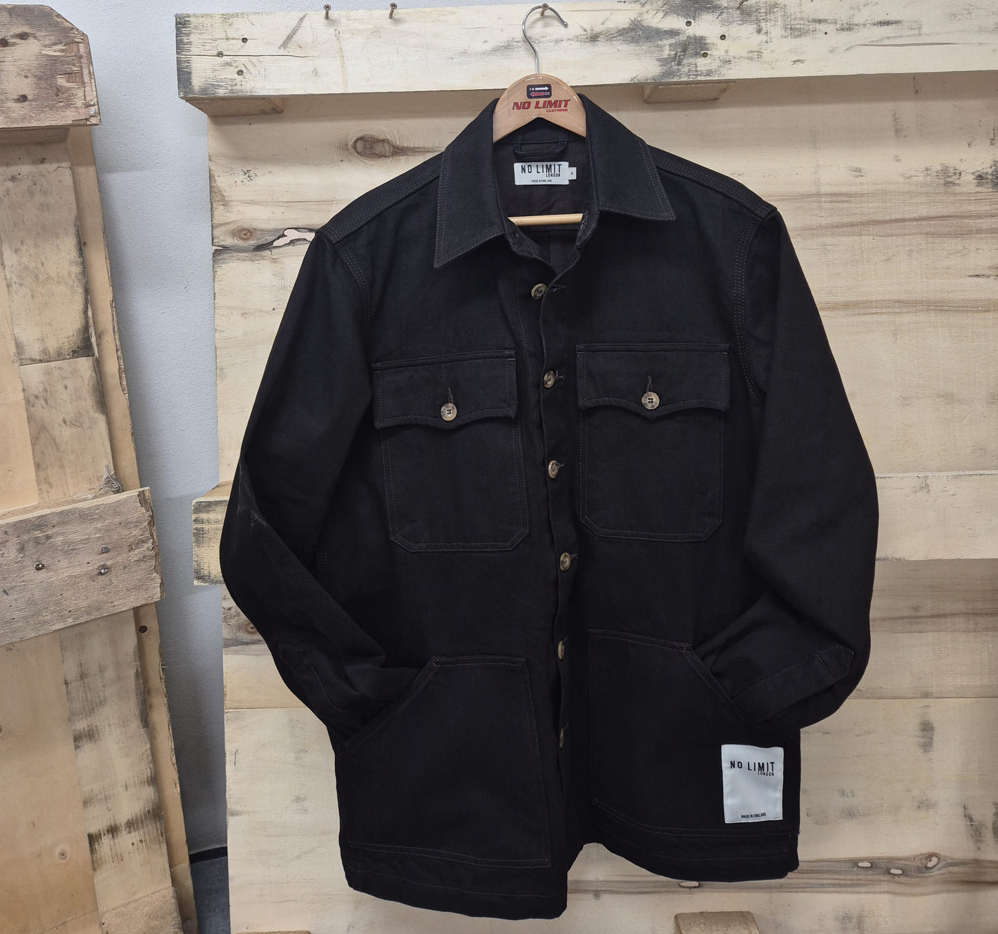 Black jacket with multiple pockets on a wooden surface