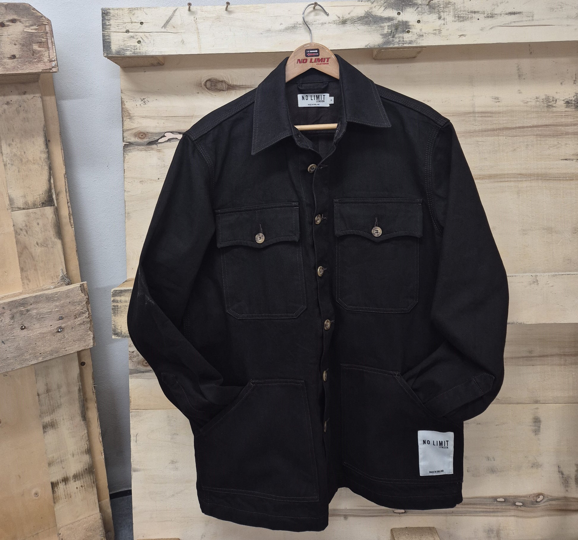 Black jacket with multiple pockets on a wooden surface